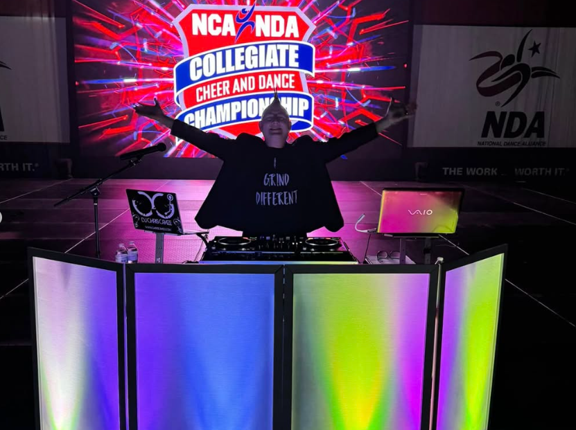 DJ booth with illuminated panels at a cheer and dance event